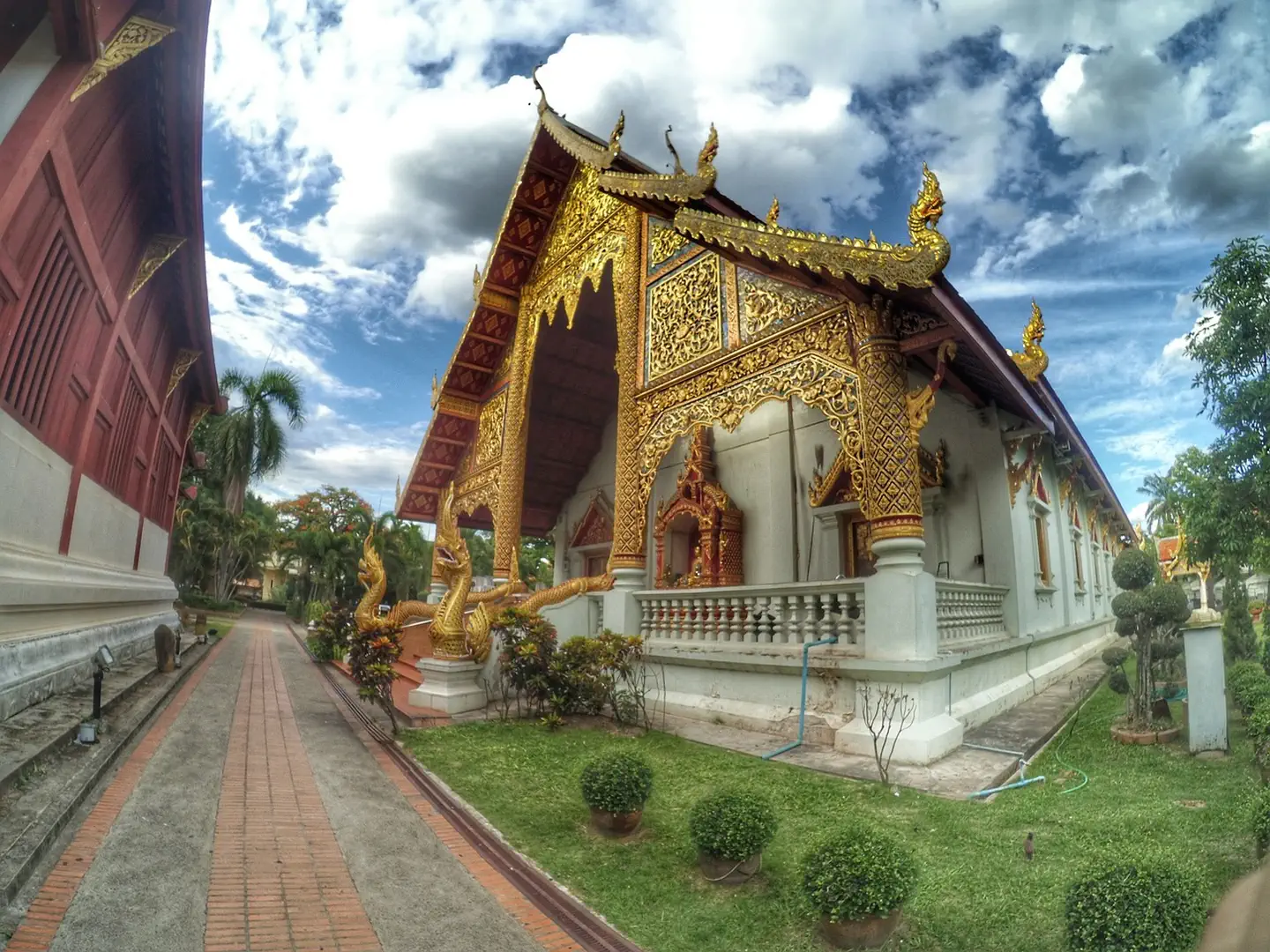 Złocona świątynia Wat Phra Singh w Chiang Mai z bogato zdobionym dachem i smokami Naga przy wejściu
