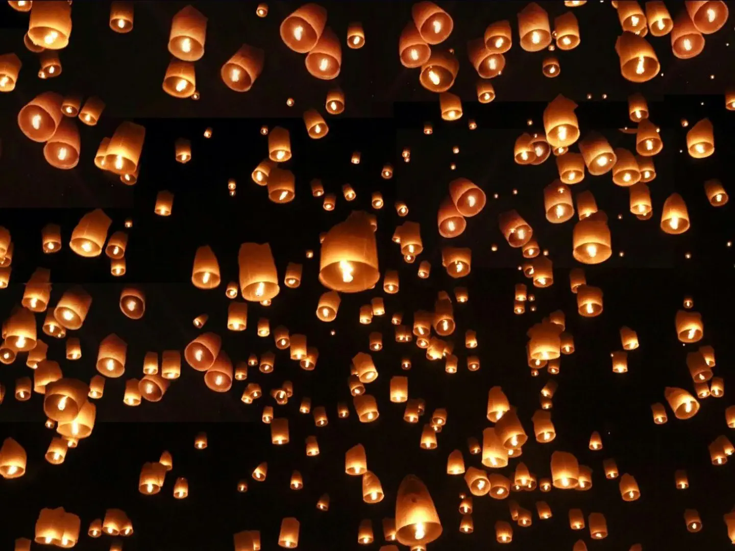 Setki unoszących się lampionów oświetlających nocne niebo podczas festiwalu Yi Peng w Chiang Mai